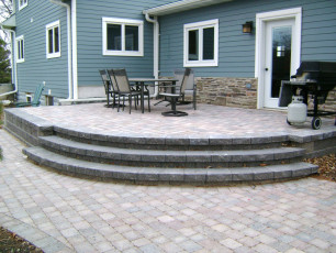 blue house with patio and paver stairs in fargo by oasis landscapes