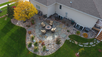 landscape with patio and yellow tree by oasis landscapes