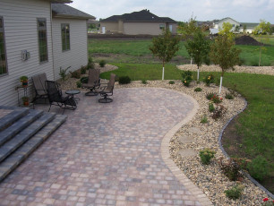paver patio with surrounding landscaping at Fargo, ND home installed by Oasis Landscapes