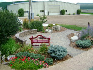 round patio with red bench and gorgeous landscaping in Fargo