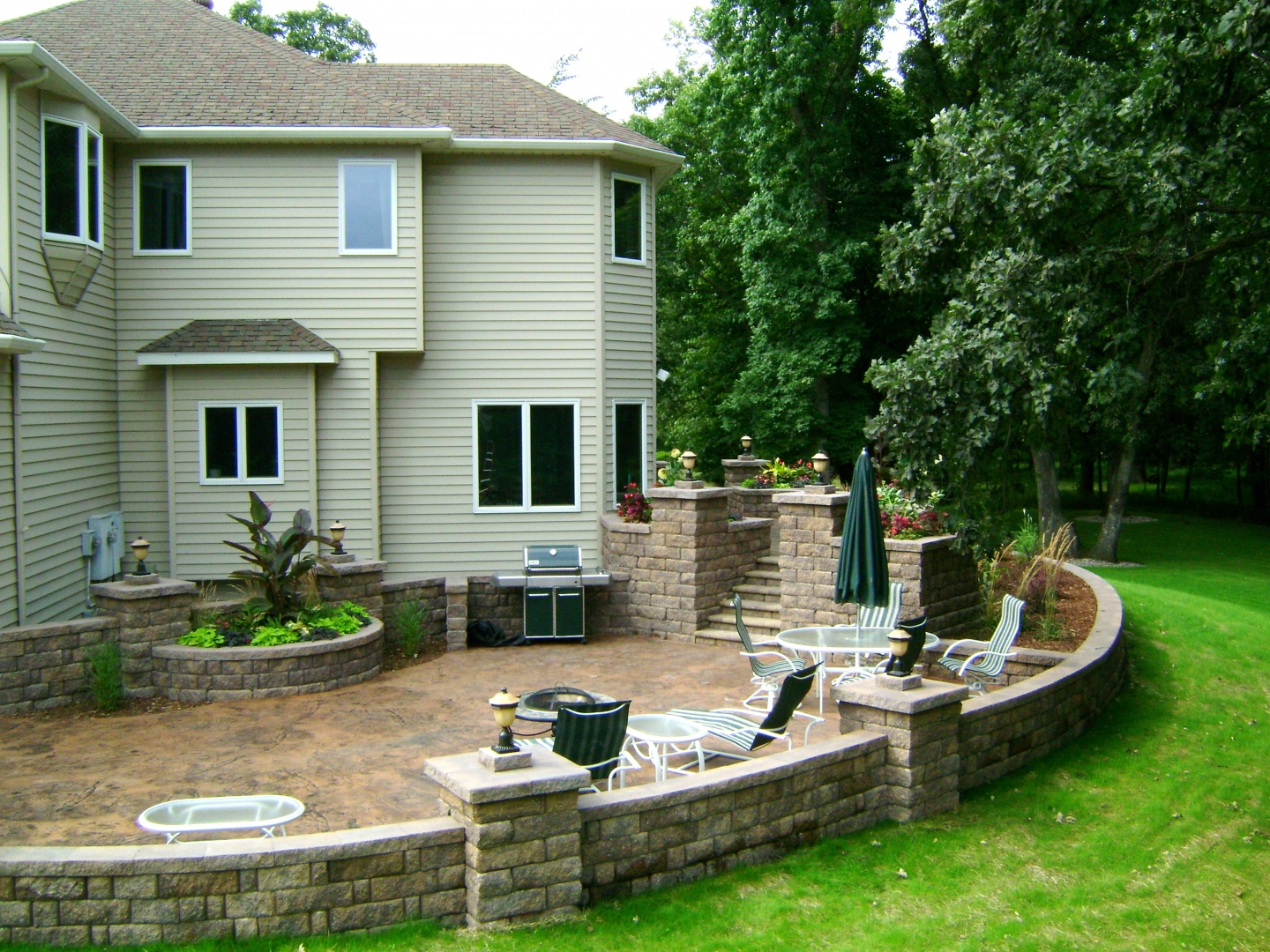 Stained Concrete Patio, Retaining Walls, Staircase, and more installed by Oasis Landscapes in West Fargo ND