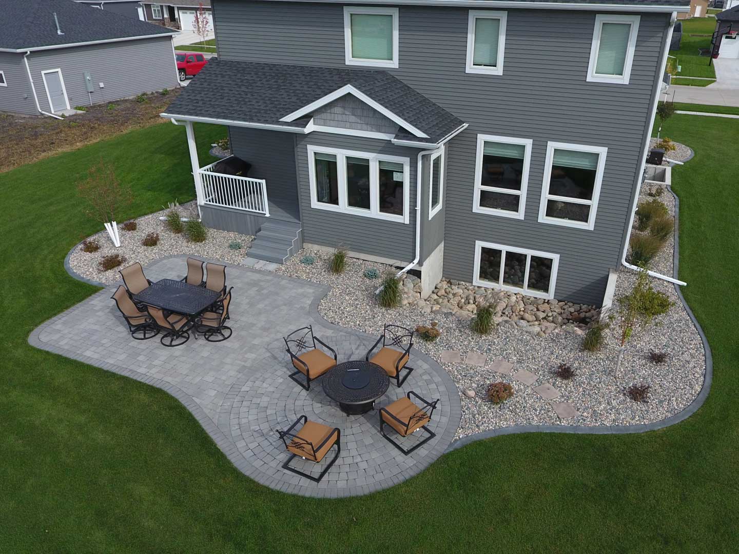 Gray paver patio with surrounding rock landscaping