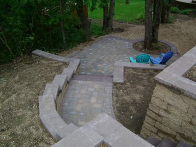 Boulder Retaining Wall with Patio and Paver Stair Case - Oasis Landscapes