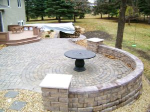 Raised paver patio with seating / safety wall by Oasis Landscapes in West Fargo